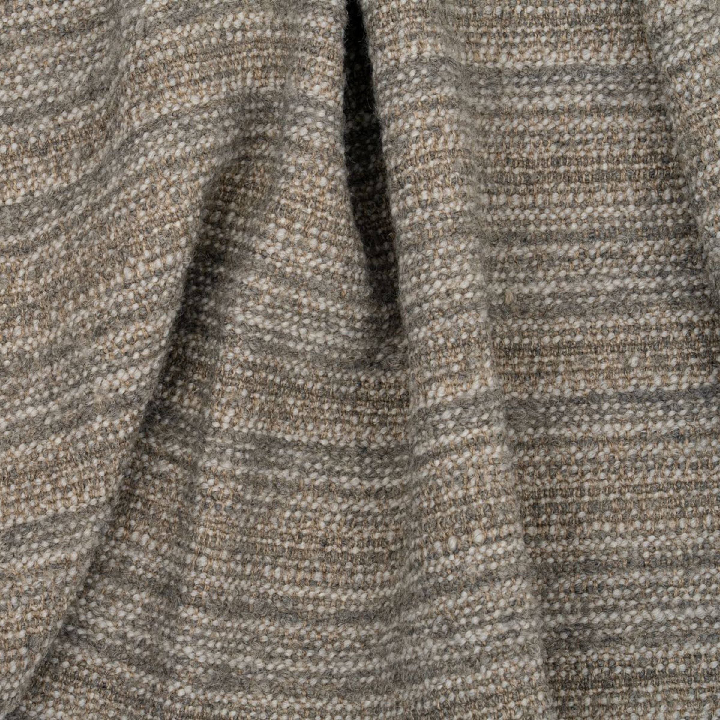 Close-up of textured gray, white and brown upholstery with a subtle fold