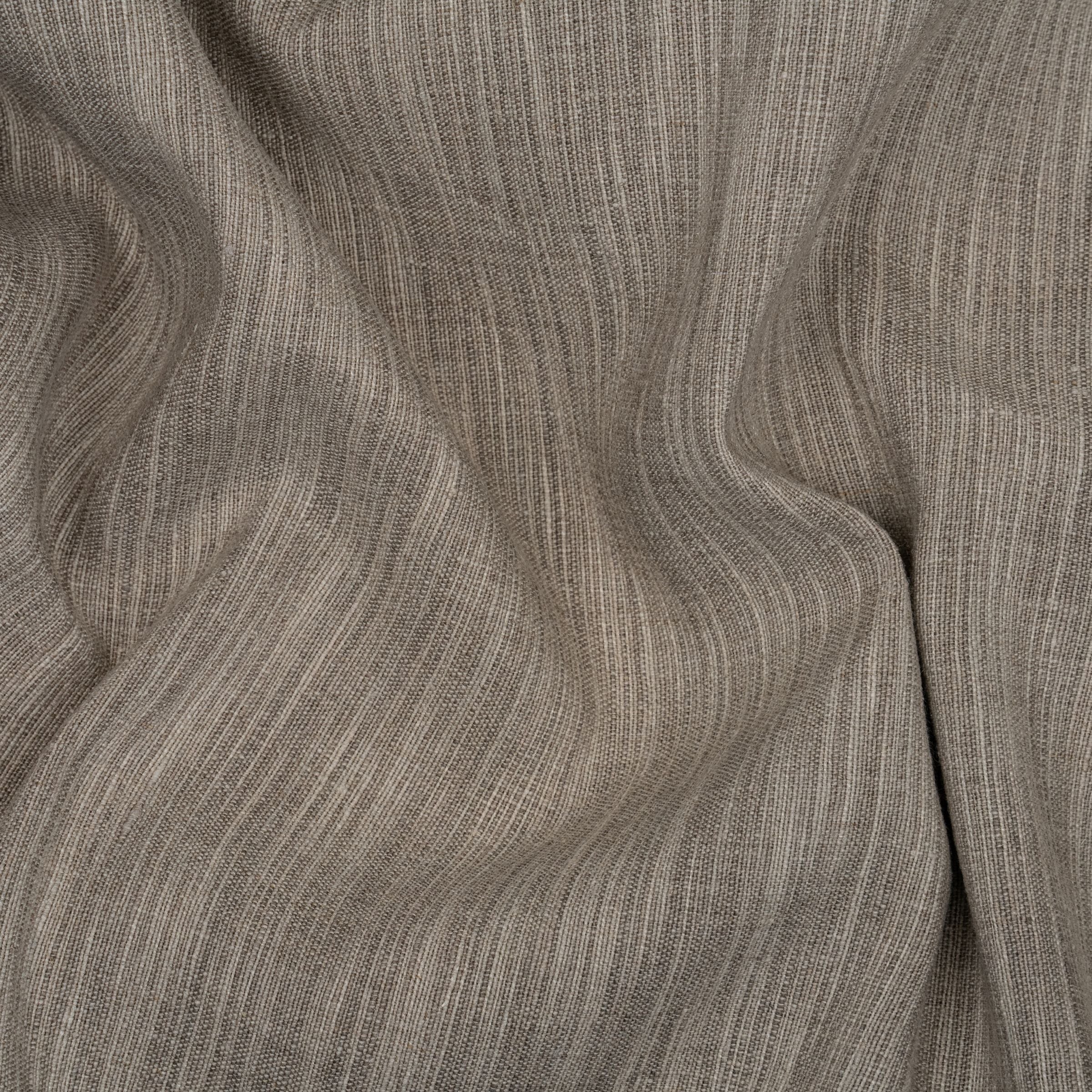 Neutral toned fabric with a textured surface due to the interwoven light and dark threads with wavy folds.