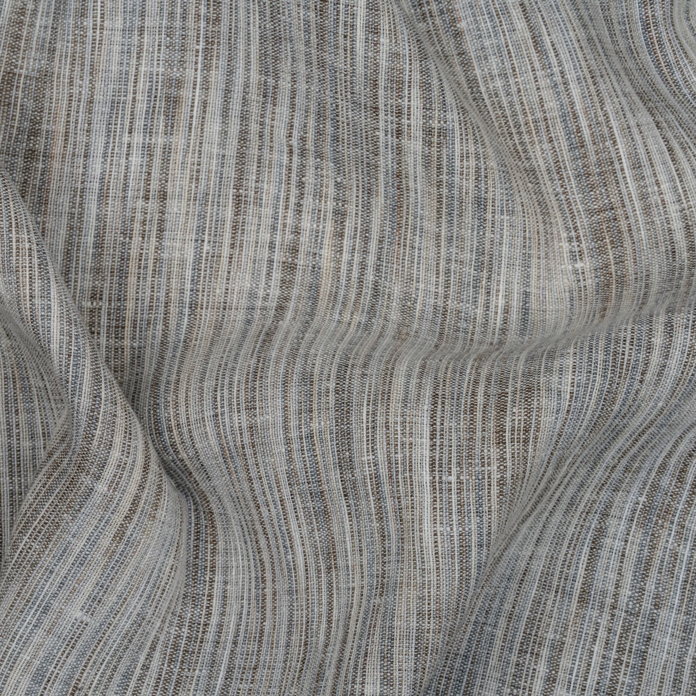Light gray fabric with visible weave and blended color of off-white and gray threads with wavy folds