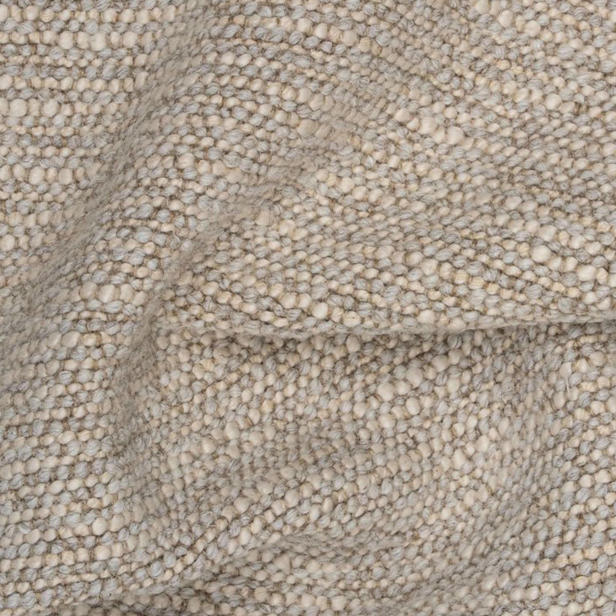 Close-up of textured stone upholstery with a wavy fold