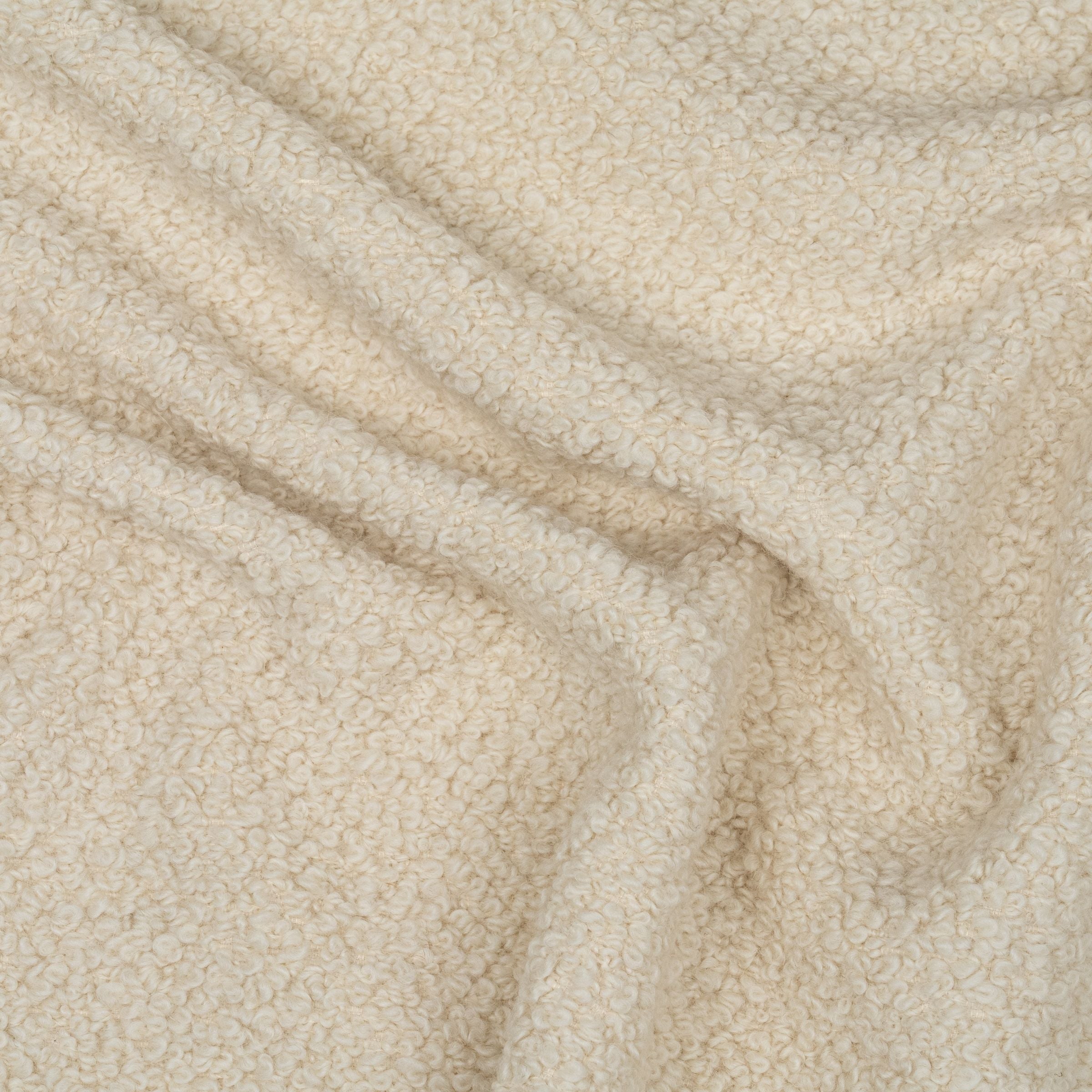 Cream colored boucle upholstery with subtle folds to show texture