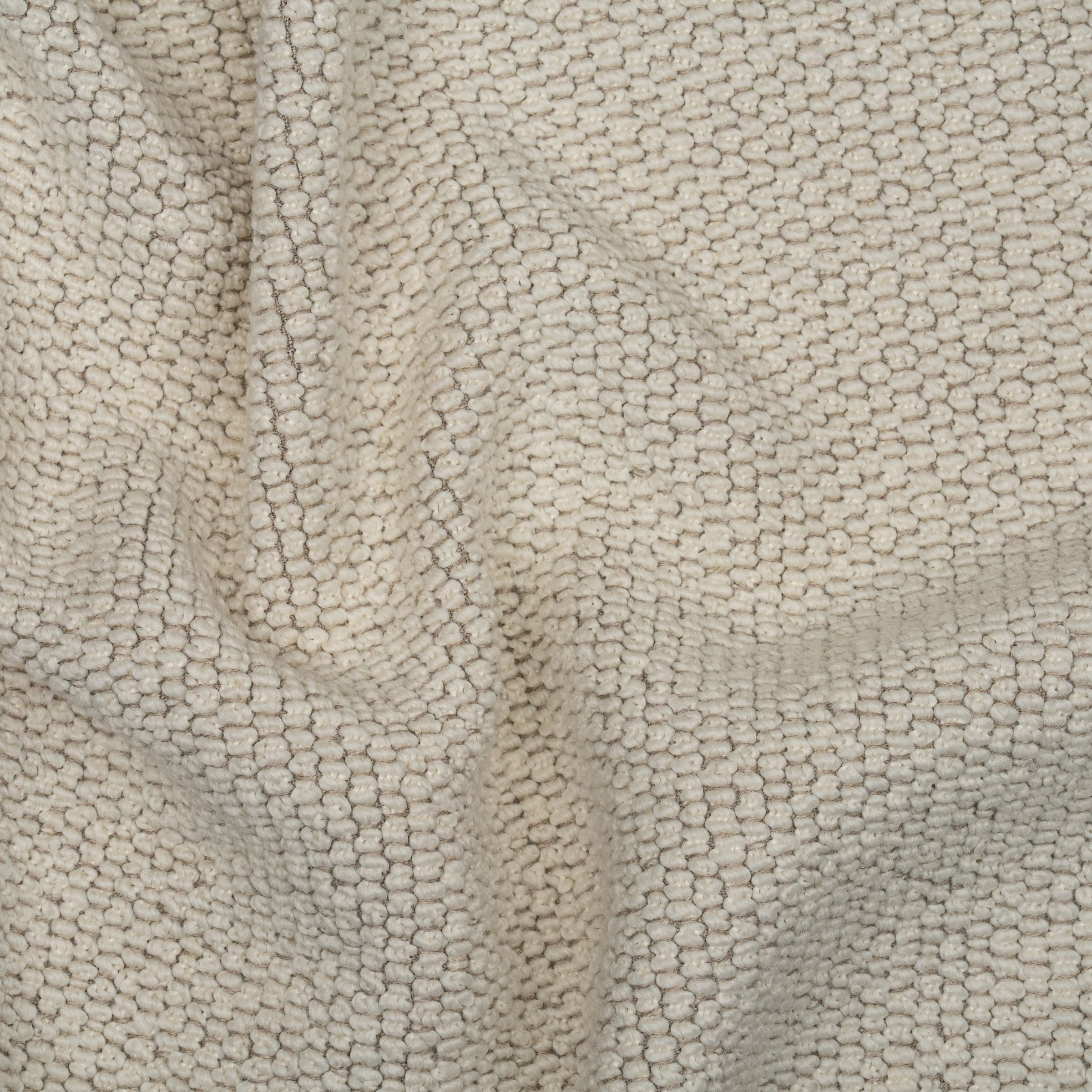 Cream colored textured upholstery fabric with subtle folds