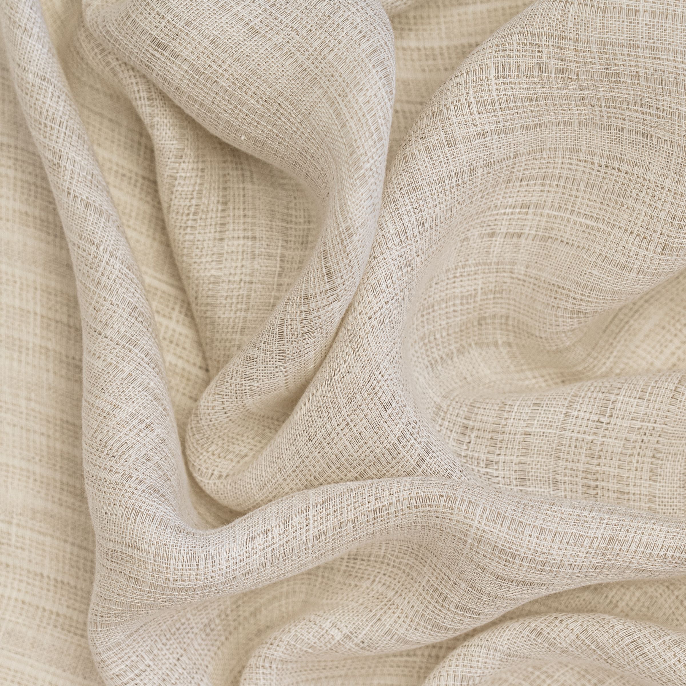 Close-up of beige textured fabric with wavy folds