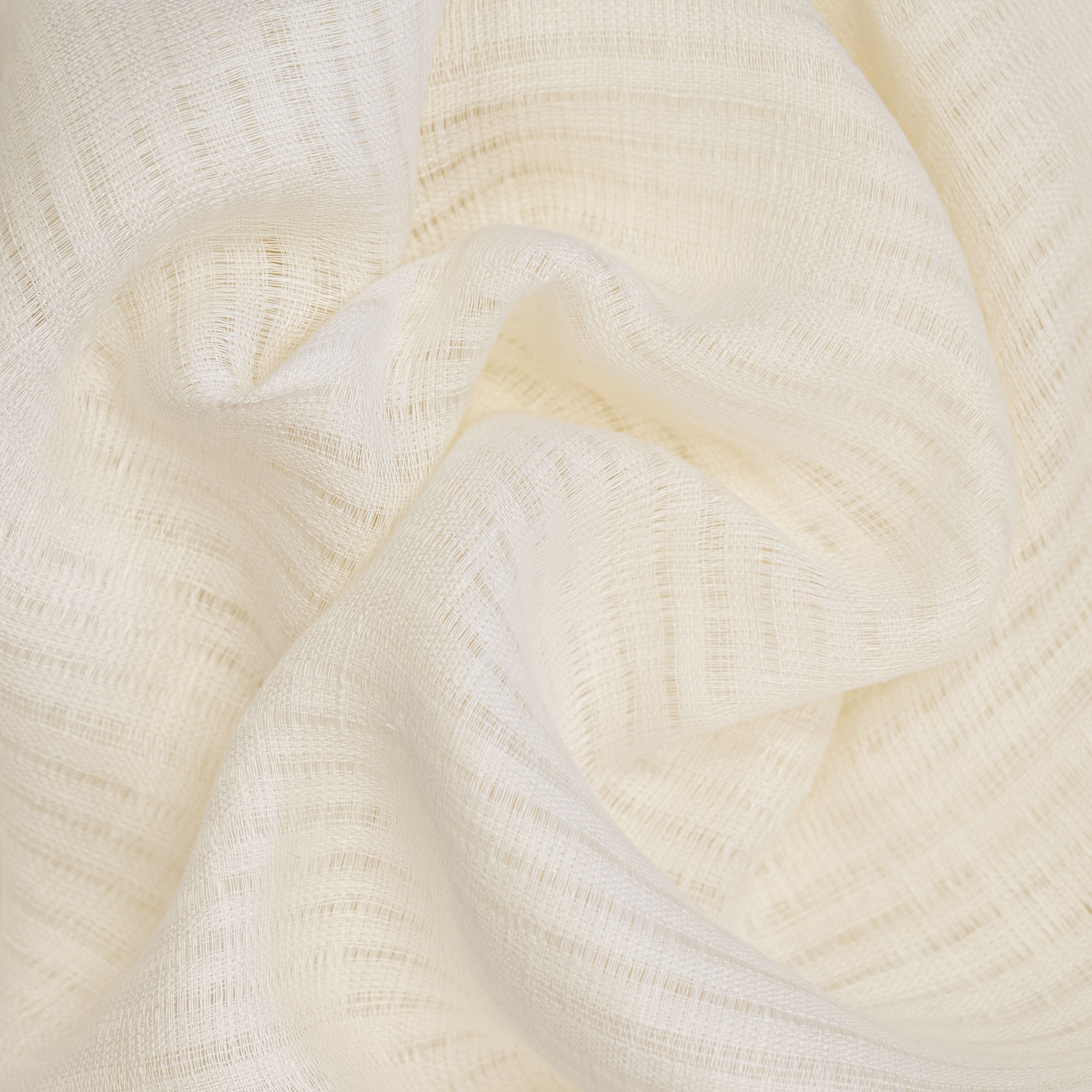Close-up of a cream-colored yarn fabric, wavy folds