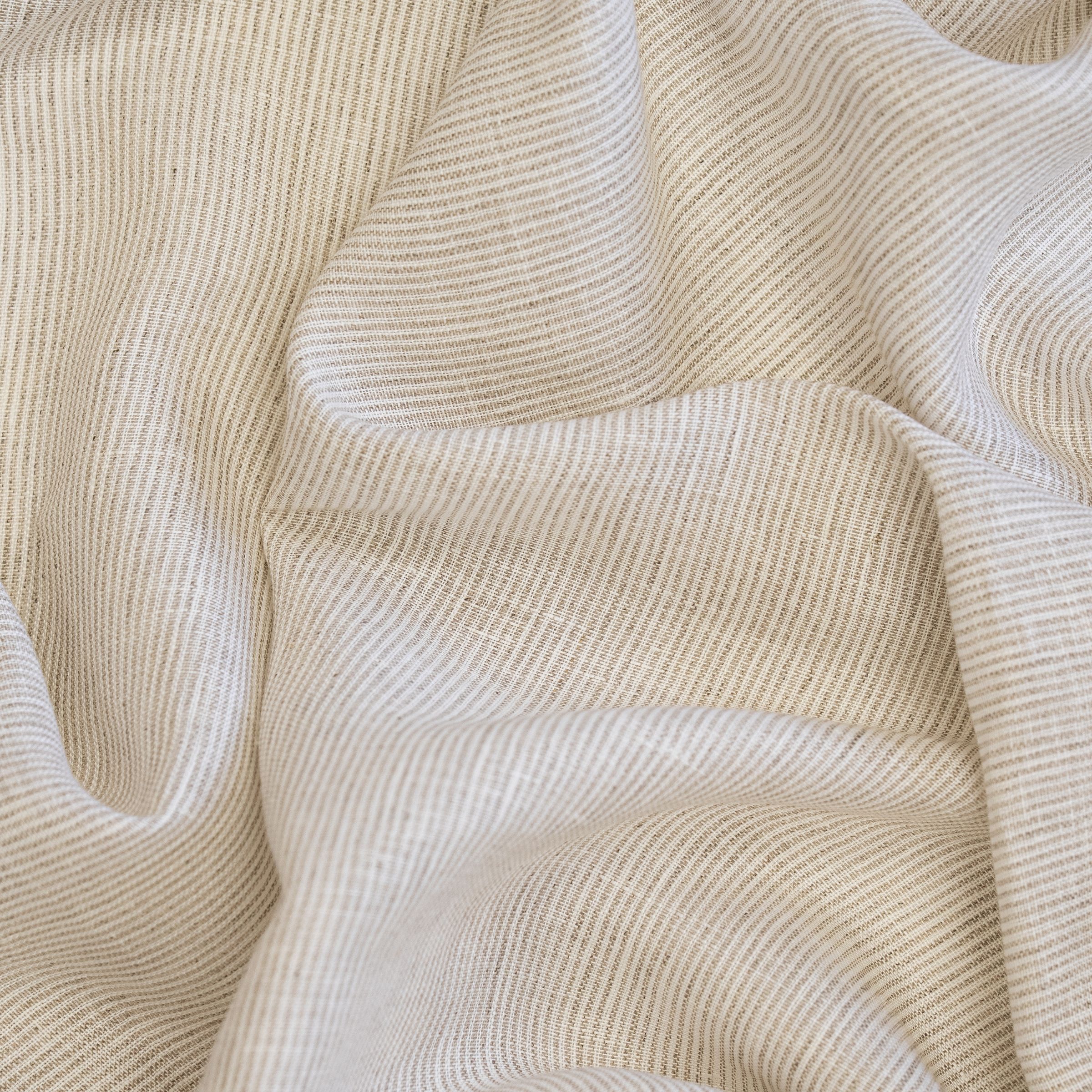 Close-up of beige striped fabric texture with natural folds