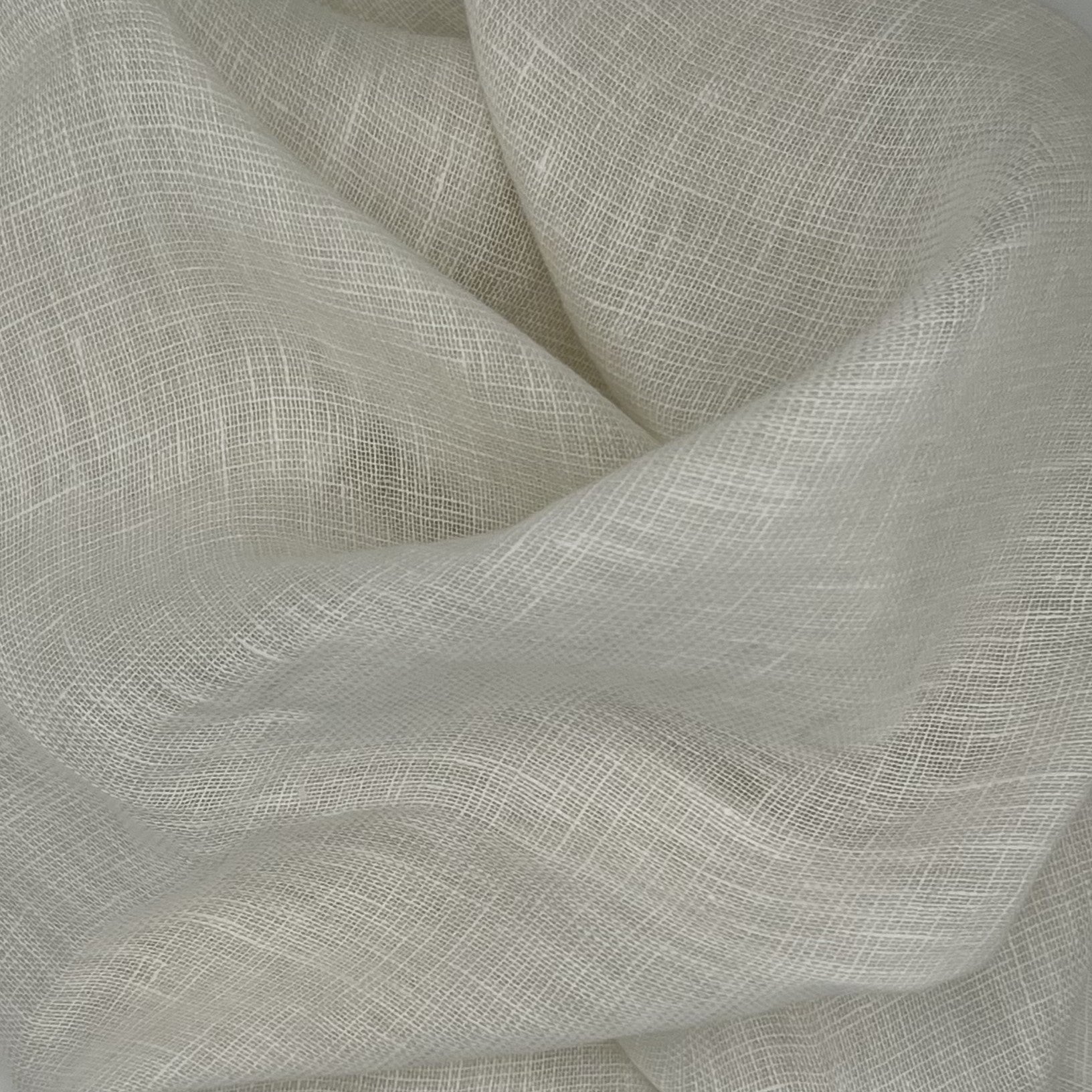 Close-up of textured off white fabric with heavy folds