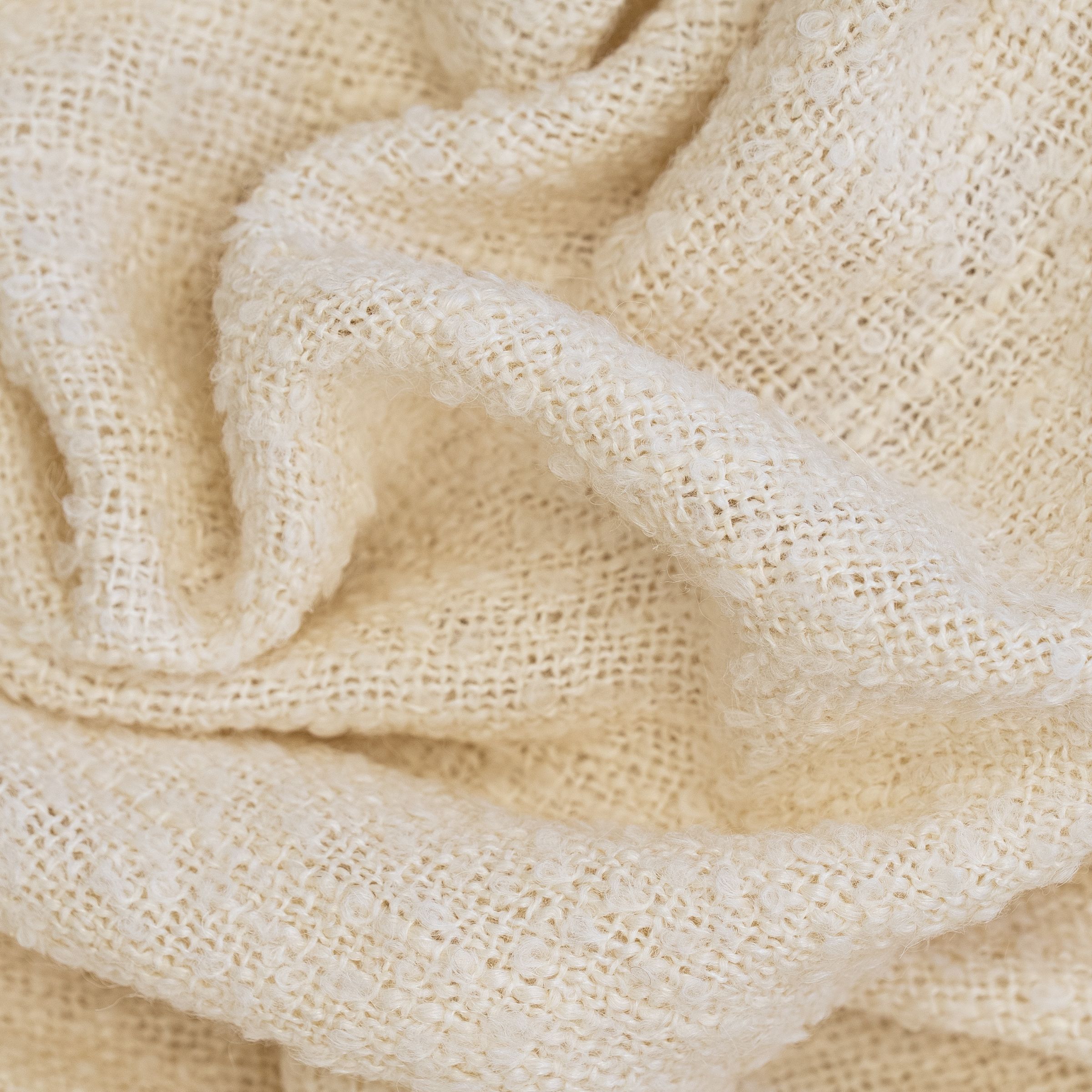 Close-up of beige textured fabric with a wavy fold