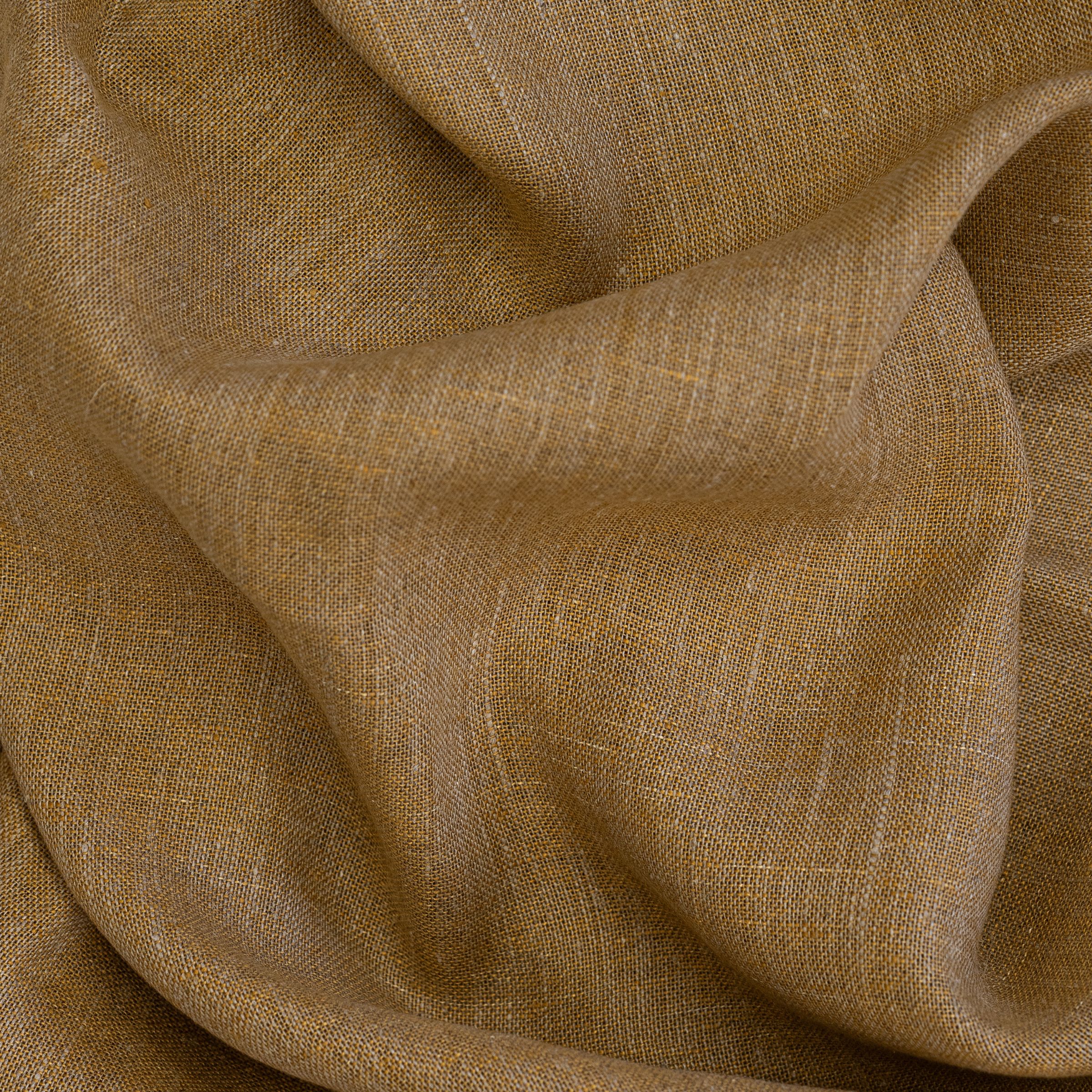 Close-up of light brown fabric with a large wavy fold