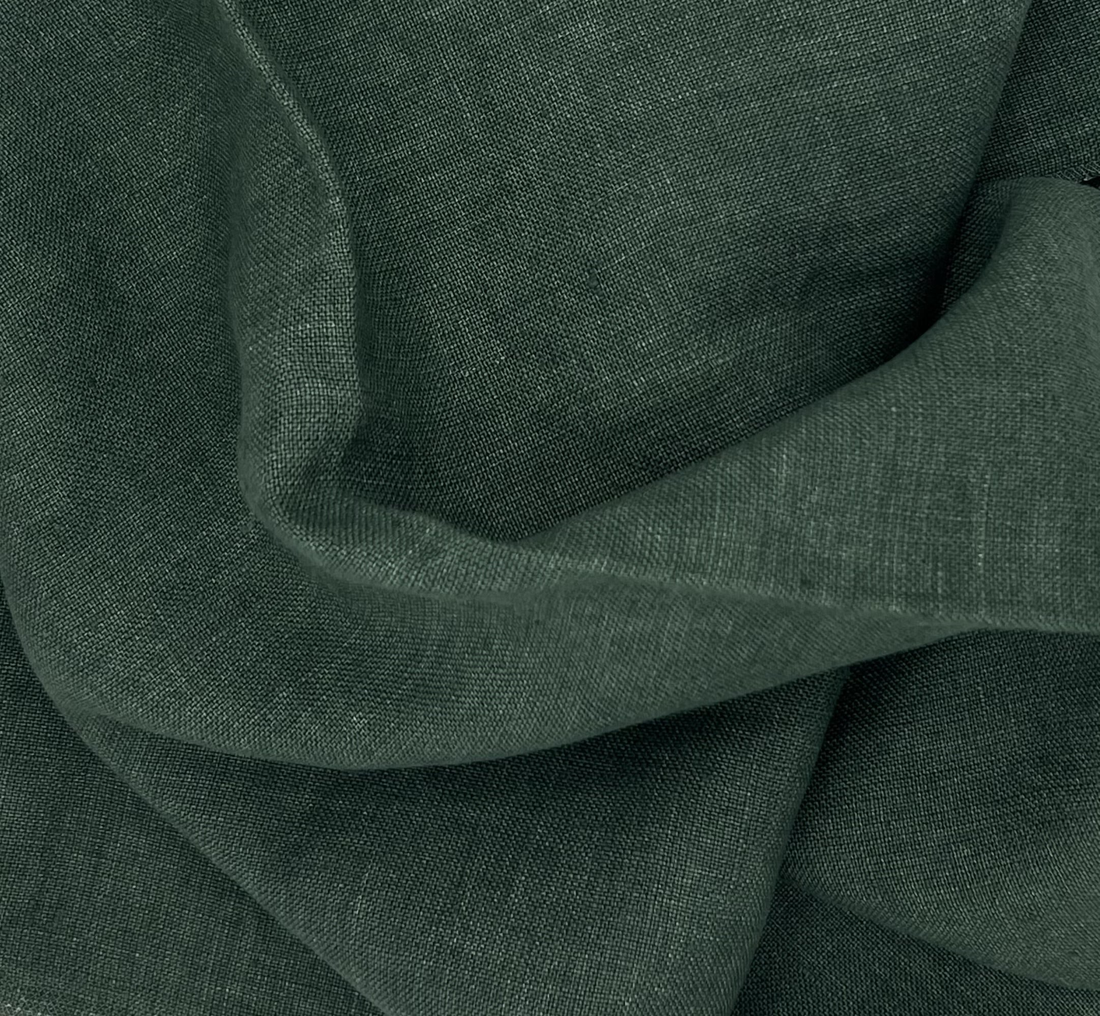 Close-up of dark green fabric with visible wavy folds