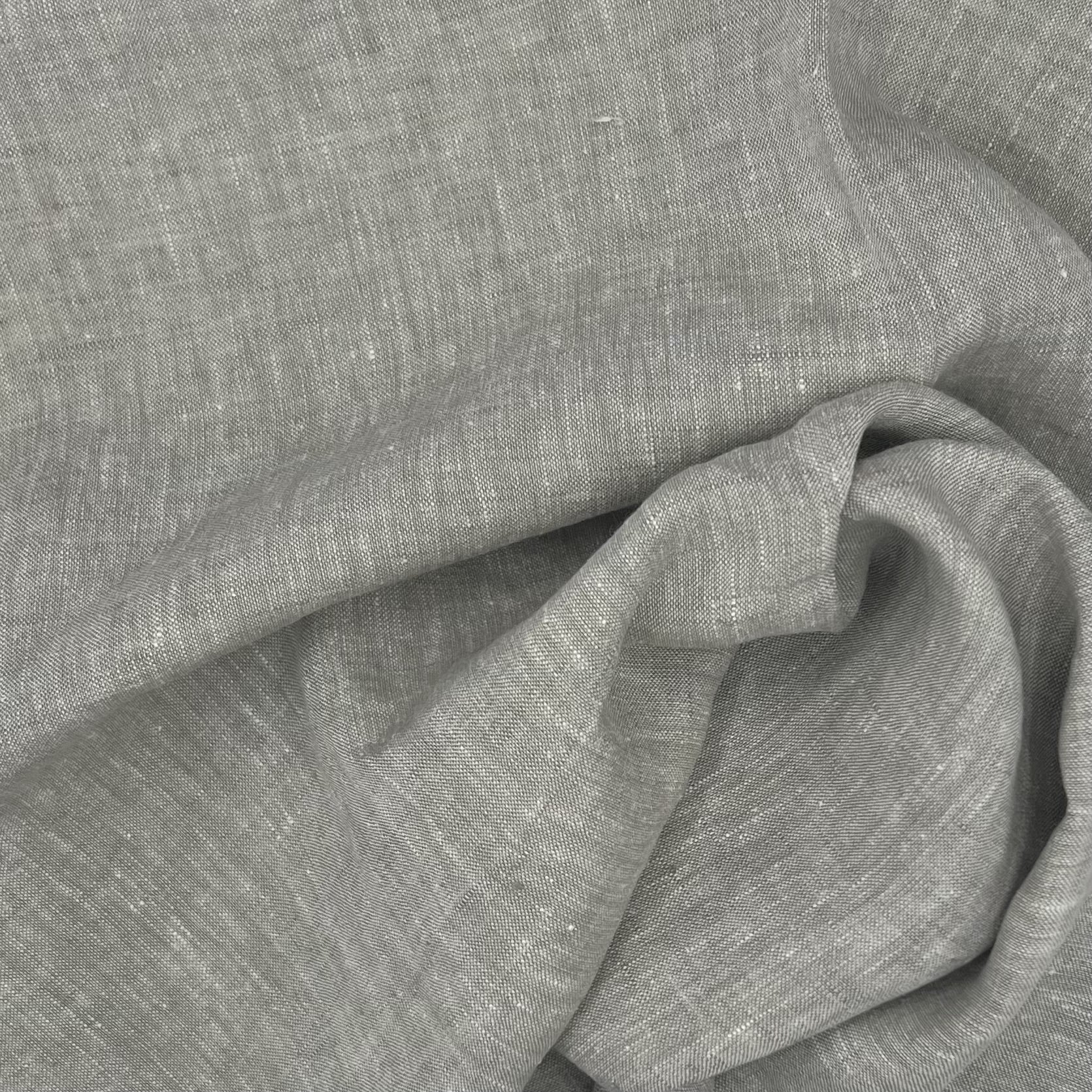 Close-up of a gray fabric with a visible textured pattern and swirl folds