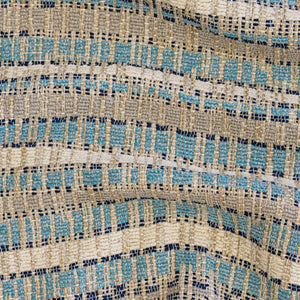 Textured upholstery with a blue and light blue pattern on a beige background with wavy folds