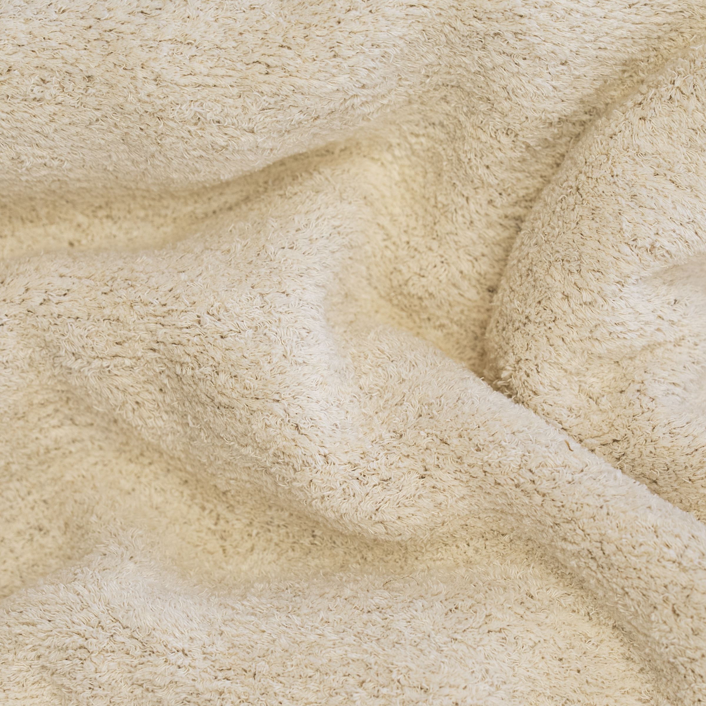 Close-up of white textured fabric with shaggy folds