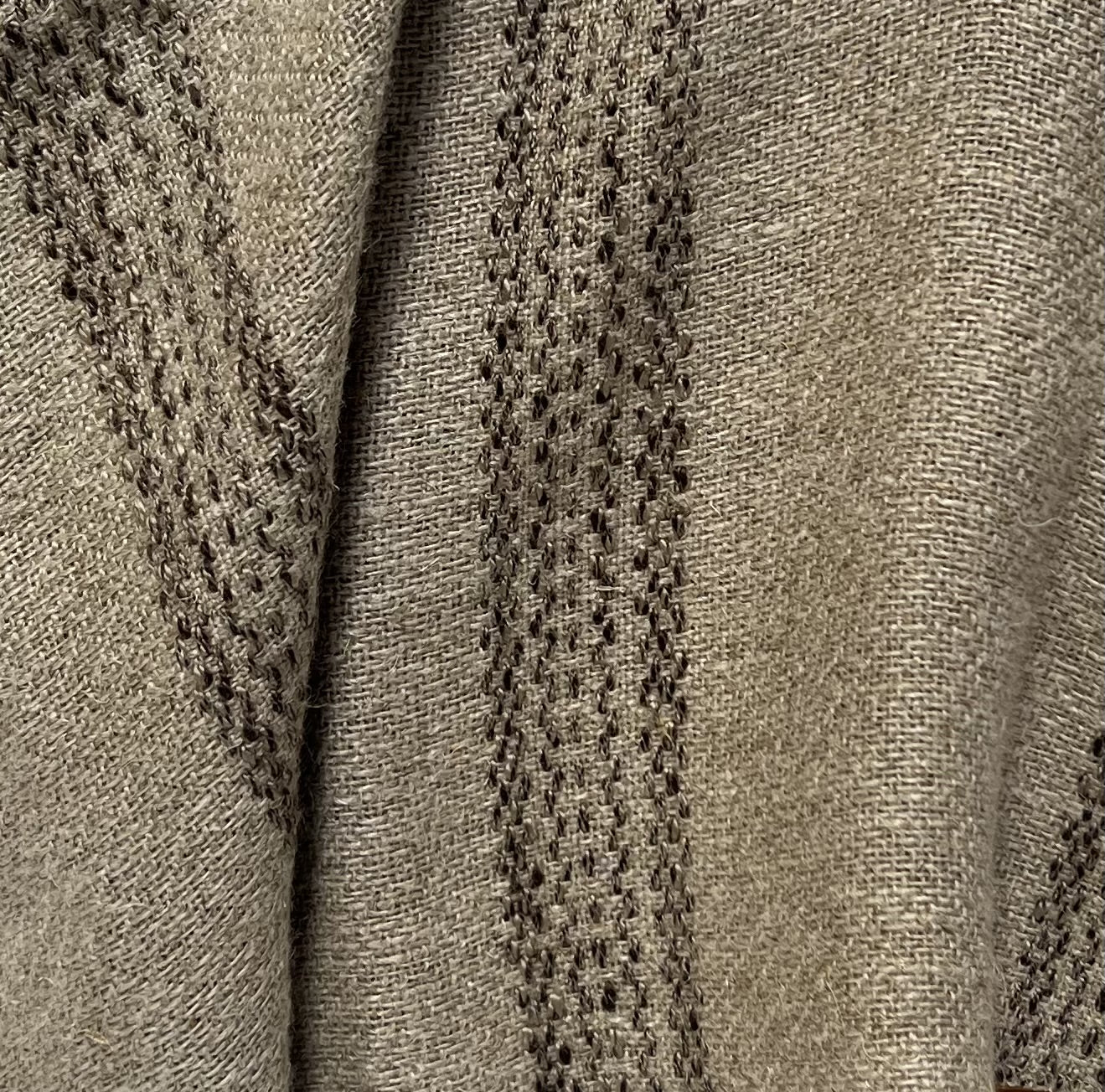 Beige fabric with a relatively loose weave and distinct, thick vertical stripes of a dark brown.