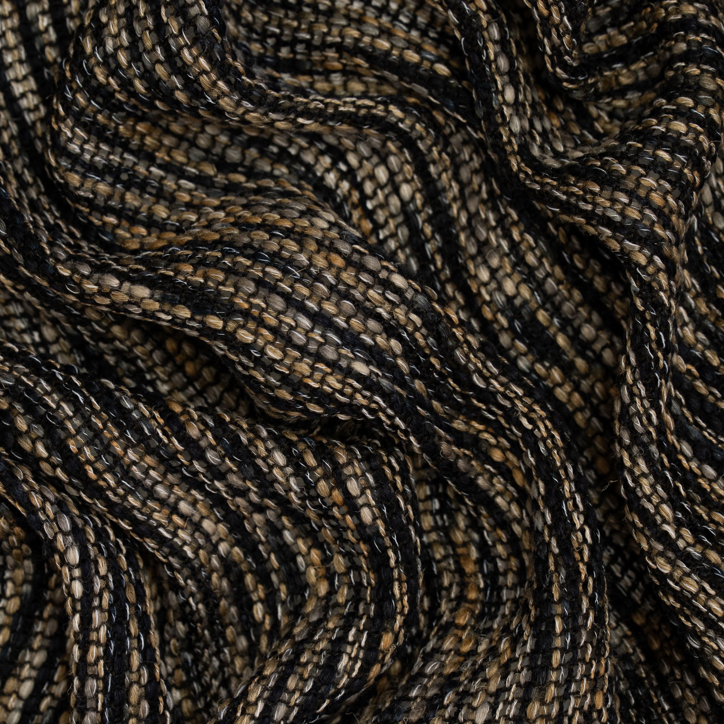 Close-up of loose weave fabric with black and brown stripes with large wavy folds