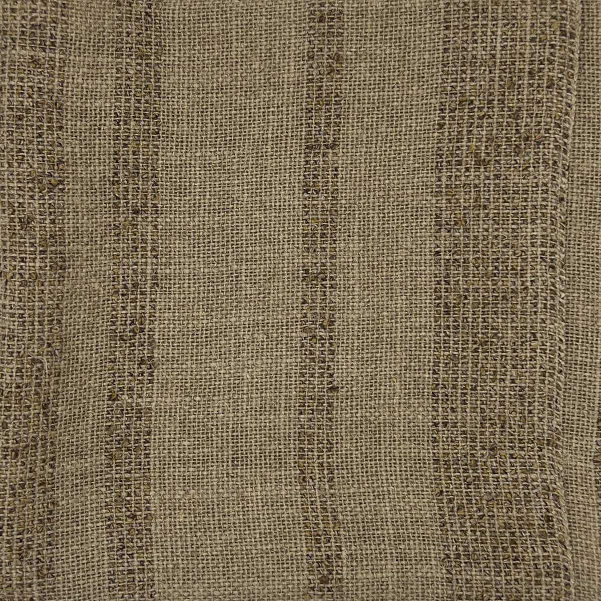 Close-up of beige fabric showing horizontal bands of brown with a visible woven texture.