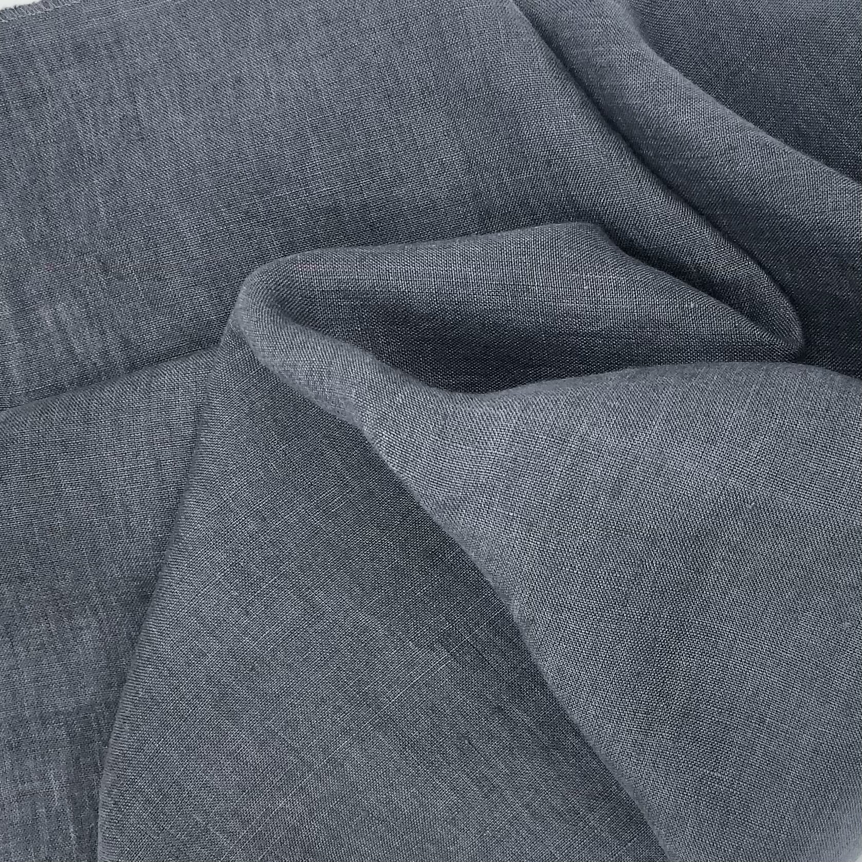 Close-up of light gray fabric with a plain weave and large wavy folds