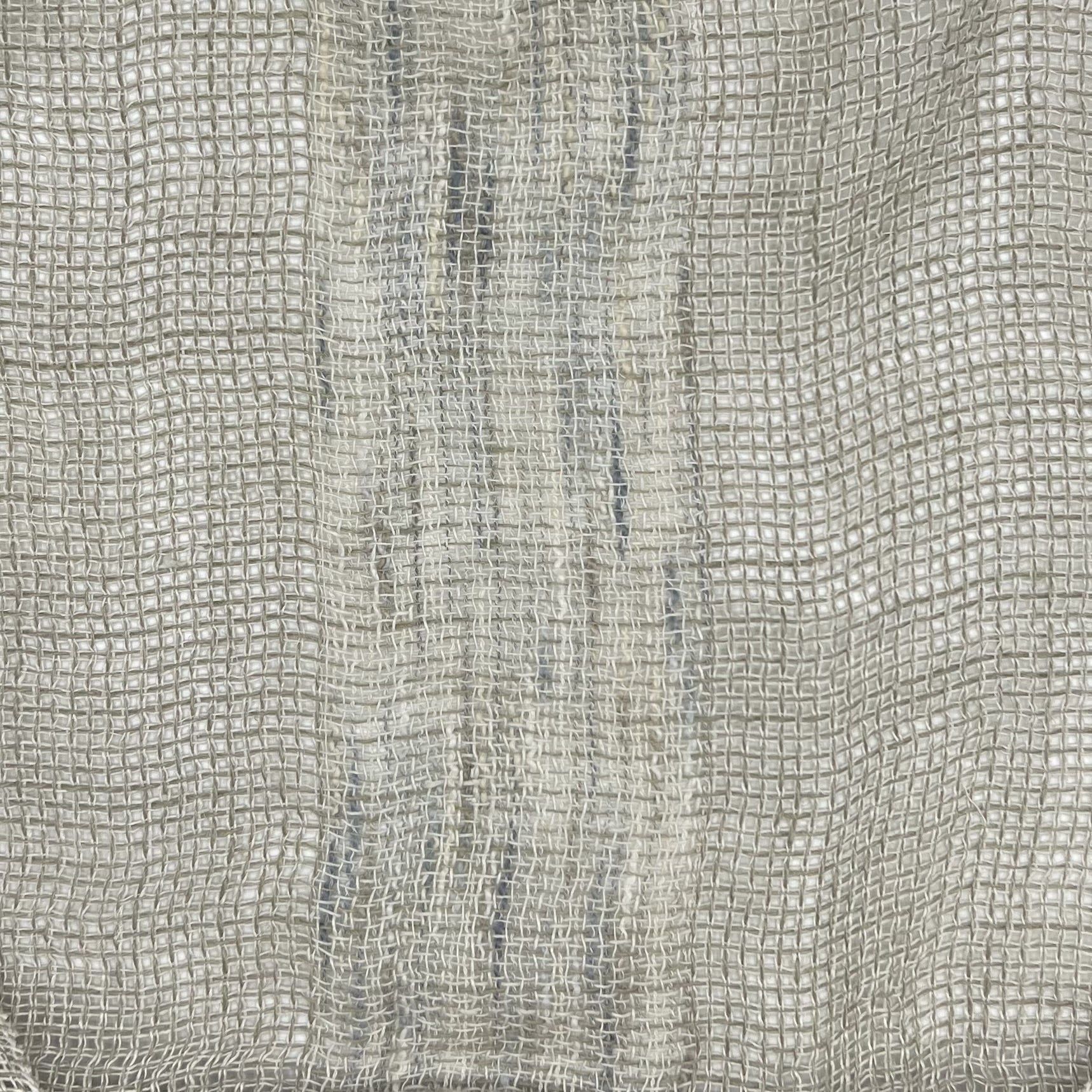 Light gray fabric highlighting the texture of the weave and the variations in thread thickness, contributing to the uneven shading.